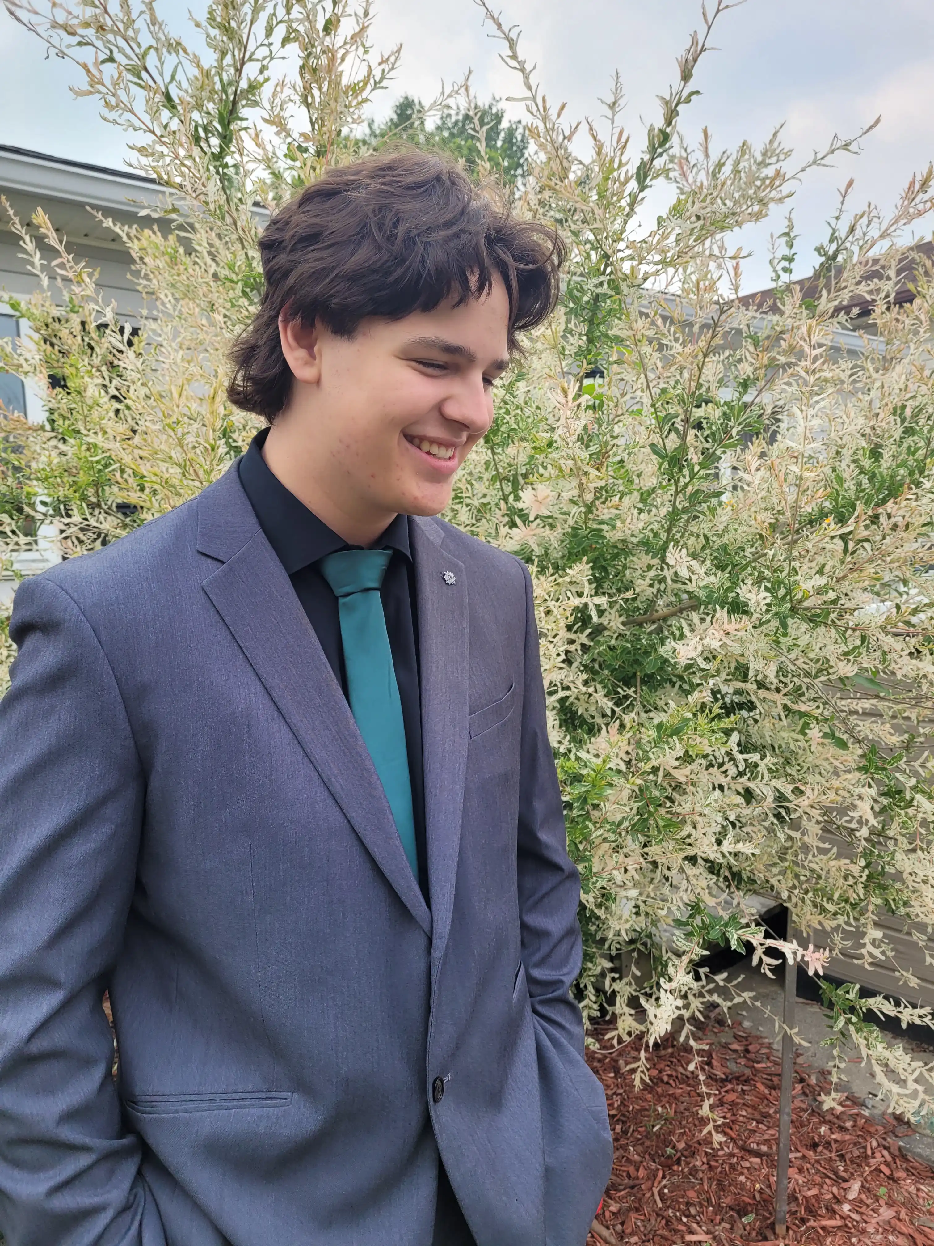 Man wearing grey suit with a green tie